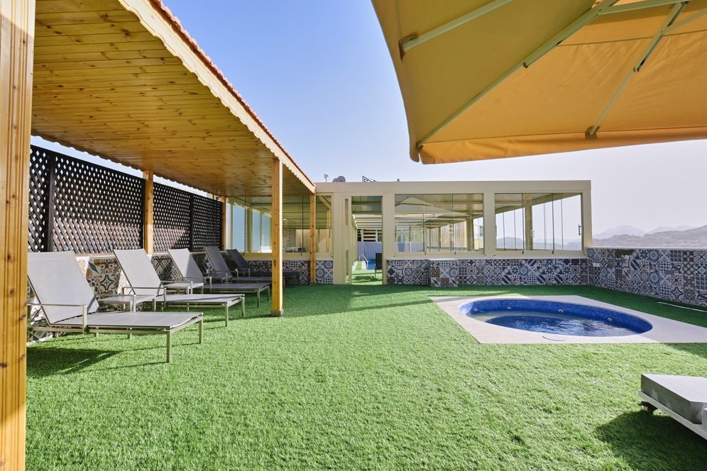 Outdoor jacuzzi and poolside lounging area at Petra Moon Hotel